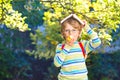 Happy little preschool kid boy with glasses, books, apple and backpack on his first day to school or nursery. Funny Royalty Free Stock Photo