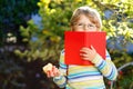 Happy little preschool kid boy with glasses, books, apple and backpack on his first day to school or nursery. Funny Royalty Free Stock Photo