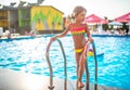 Happy little pretty girl in colored bathing suit