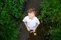 happy little school kids boy having fun walking through water in river in gum rubber boots. child portrait of healthy Royalty Free Stock Photo