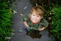 happy little school kids boy having fun walking through water in river in gum rubber boots. child portrait of healthy Royalty Free Stock Photo