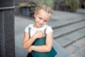 Happy little schoolgirl with book going back to school outdoor.