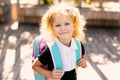 Happy little schoolgirl with school bag in school garden. Back to school outdoor Royalty Free Stock Photo