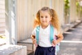 Happy little schoolgirl with school bag in school garden. Back to school outdoor Royalty Free Stock Photo