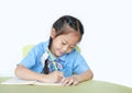 Happy little schoolgirl writing on notebook at desk isolated on white background. Children and Education concept Royalty Free Stock Photo