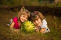 Happy little sisters lie on grass and hug very big watermelon in sunny day Royalty Free Stock Photo