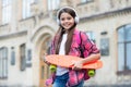 Happy little skater girl hold skating board listening to music in headphones summer urban outdoors, penny Royalty Free Stock Photo