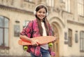 Happy little skater girl hold skating board listening to music in headphones summer urban outdoors, penny Royalty Free Stock Photo