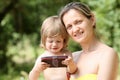 Happy little smiling child in the arms of the mother on a natural background Royalty Free Stock Photo