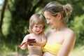 Happy little smiling child in the arms of the mother on a natural background Royalty Free Stock Photo