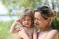 Happy little smiling child in the arms of the mother on a natural Royalty Free Stock Photo