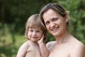 Happy little smiling child in the arms of the mother on a natural Royalty Free Stock Photo