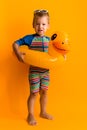 happy little smiling child swimmer sport boy wear sun glasses swimsuit, Kid Inflatable swimming ring yellow duck point Royalty Free Stock Photo