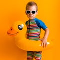 happy little smiling child swimmer sport boy wear sun glasses swimsuit, Kid Inflatable swimming ring yellow duck point Royalty Free Stock Photo