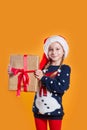 Happy little smiling girl in Santa hat with big christmas gift box Royalty Free Stock Photo