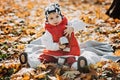 Happy little toddler baby daughter with red thermos and cup in autumn picnic in fall nature background Royalty Free Stock Photo