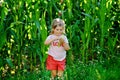 Happy little toddler girl playing on corn labyrinth field on organic farm, outdoors. Funny child hild having fun with running, Royalty Free Stock Photo