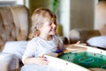 Happy little toddler girl playing table soccer with family at home. Smiling child winning board football, indoors Royalty Free Stock Photo