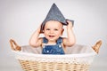 Happy little toddler sitting inside the wicker basket