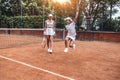 Happy little winner! Full length shot of two sporty girls in tennis club. Happy child having fun on tennis court with woman tennis Royalty Free Stock Photo