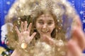 Happy little 10 years girl looking at camera through a christmas ball in festive  decorated home interrior Royalty Free Stock Photo