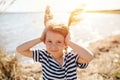 Happy lively little girl with cereal antennas by the lake at spring