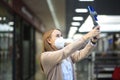 Happy long-haired girl in mask makes report in TV-mall on the phone stabilizer Steadicam. Social Media Marketing employee at work