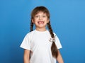Happy lost tooth girl portrait, studio shoot on blue background