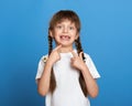 Happy lost tooth girl portrait, studio shoot on blue background