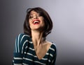 Happy loudly laughing with wide open mouth young woman with short hair in fashion sweater. portrait