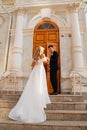 happy and in love bride and groom at the steps of the building in retro style. Royalty Free Stock Photo