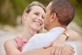 A happy, love and diversity couple hug outside on their honeymoon, vacation or holiday. Man and woman together in