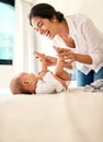 Happy, love and a mother with her baby on the bed in their home together for playful bonding. Family, children and a Royalty Free Stock Photo