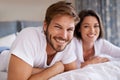 Happy, love and portrait of couple relaxing, bonding and resting on bed together at home. Smile, romantic and young man Royalty Free Stock Photo