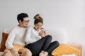 Happy lovely asian couple sharing smartphone to watch together in living room