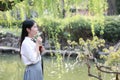 Happy lovely beauty Asia Chinese high school girl student smile enjoy free time in a park garden spring summer drink water cola Royalty Free Stock Photo