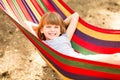 Happy lovely child girl relaxing in colorful hammock in summer forest Royalty Free Stock Photo