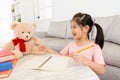 Happy lovely girl children teaching her teddy toy Royalty Free Stock Photo