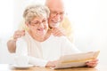 Happy and lovely senior couple reading newspaper