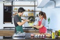 Happy lovely young Asian couple with casual clothes in modern kitchen is helping, preparing, cooking healthy food as fresh organic Royalty Free Stock Photo