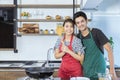 Happy lovely young Asian couple in love with Casual clothes is smiling, looking at camera, and preparing to cook healthy food in Royalty Free Stock Photo