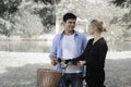 Happy lovely young couple with bike walking in the garden spending time together. Lover going on a picnic in summer park and