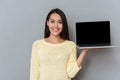 Happy lovely young woman holding blank screen laptop Royalty Free Stock Photo