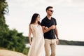 Happy lovers at the beach near lake. Young couple is holding hands and walking on summer day outdoors. A man and woman in love. Royalty Free Stock Photo