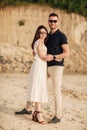 Happy lovers at the beach near lake. Young couple is hugging at sunset on summer day outdoors. A man and woman in love. Concept of Royalty Free Stock Photo