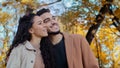 Happy lovers husband and wife ethnic multiracial married couple in autumn park smiling Caucasian woman with Hispanic man Royalty Free Stock Photo