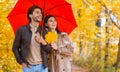 Happy lovers walking under red umbrella at rainy autumn day Royalty Free Stock Photo