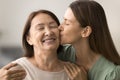 Happy loving adult daughter woman hugging and kissing senior mom Royalty Free Stock Photo