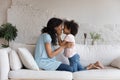 Happy loving African American mother kissing adorable preschool daughter Royalty Free Stock Photo