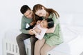 Happy loving Asian family. Portrait of beautiful mother and father are playing with daughter in the bedroom at home. Weekend Royalty Free Stock Photo